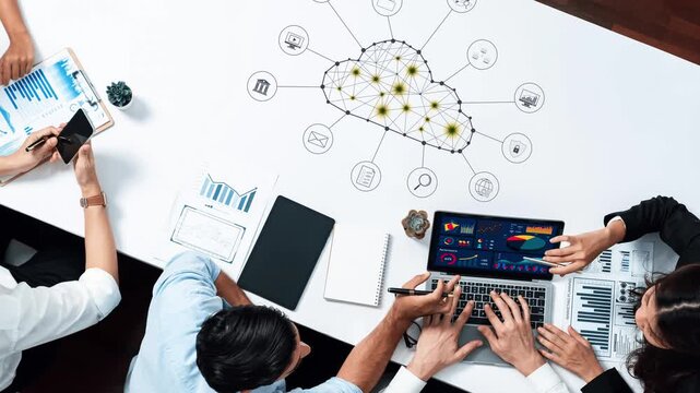 Professionals engage in a collaborative meeting focused on data analytics and visualization, showcasing cloud technology integration in a modern office setting. Raster