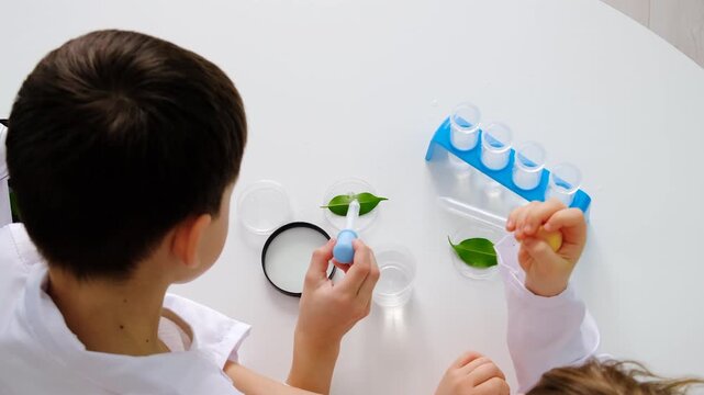 Laboratory examination of a child with test tubes, reagents and a microscope. Selective focus.