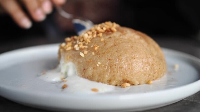 Person Eating Semolina Halva with Ice Cream and Crushed Nuts