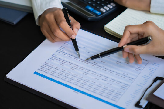 Asian businesswoman using pen pointing at document