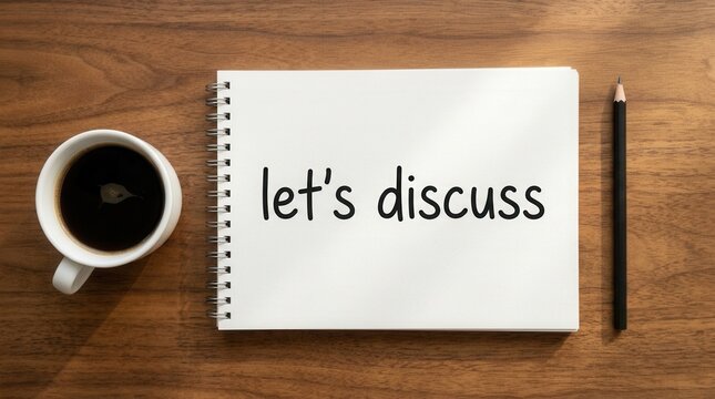 Notebook with text lets discuss next to coffee cup and pencil on wood table for brainstorming.