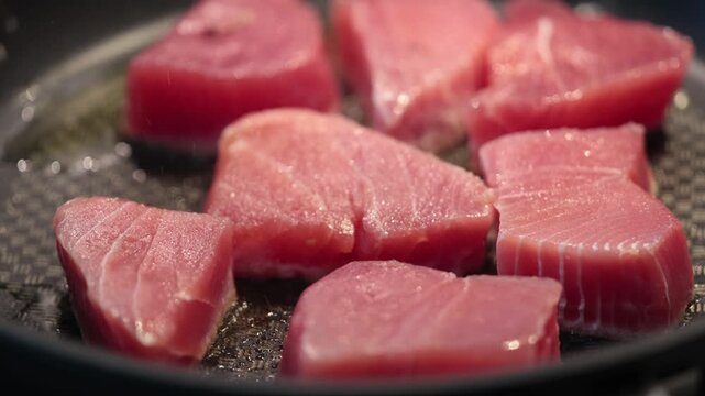 Stockholm, Sweden Raw tuna steaks frying n a frying pan. 