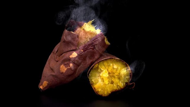 Fresh roasted sweet potato cut in half with hot steam rising up