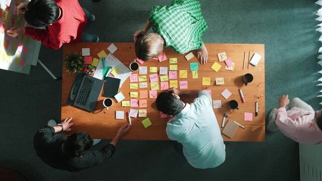 Time lapse of business team choose brainstorming idea and stick sticky notes at whiteboard. Group of diverse people working together sharing idea by using notes and equipment at table. Convocation.