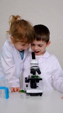 Laboratory examination of a child with test tubes, reagents and a microscope. Selective focus.