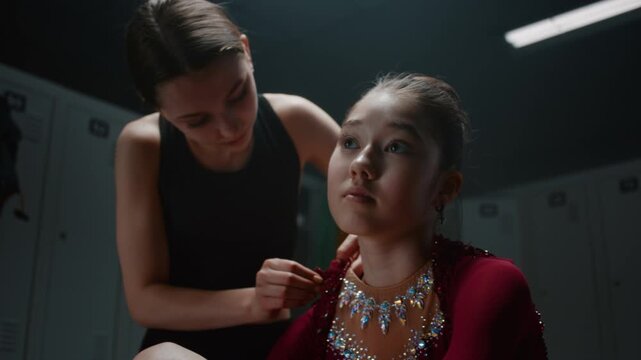 One Supportive Teammate Carefully Helps Tired Gymnast Zip Up Shiny, Rhinestone Embellished Competition Suit. Raw Emotional Exhaustion, Pre Performance Pressure, Focus of Elite Rhythmic Gymnastics.