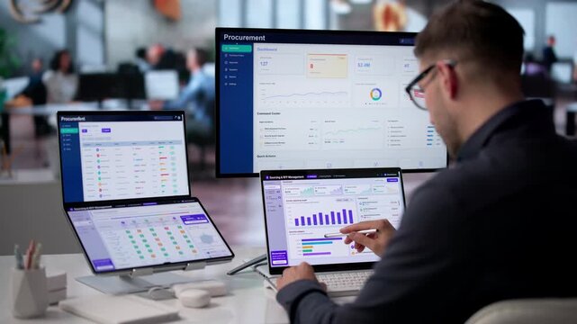 Procurement Manager Analyzes Software On Dual Screen Laptop