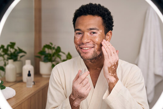 Beauty creator applies skincare product while smiling in a well-lit studio Generative AI