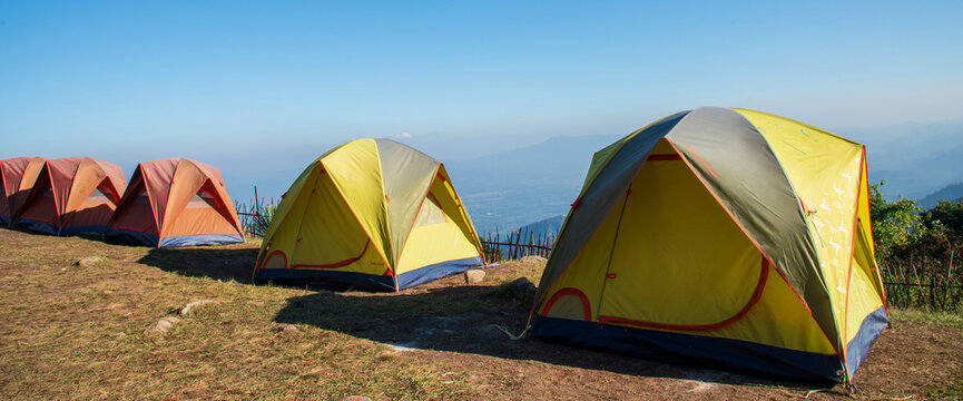 Banner Tent Camping trip outdoor hiking mountain hill. Tent camp in nature background sunrise top mountain. Adventure Travel with copy space. Banner Picnic tent green nature campground forest