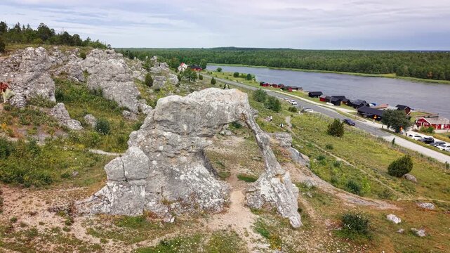Limestone formations overlook a small coastal fishing village on Gotland, Sweden, creating a dramatic geological landmark beside the Baltic Sea.