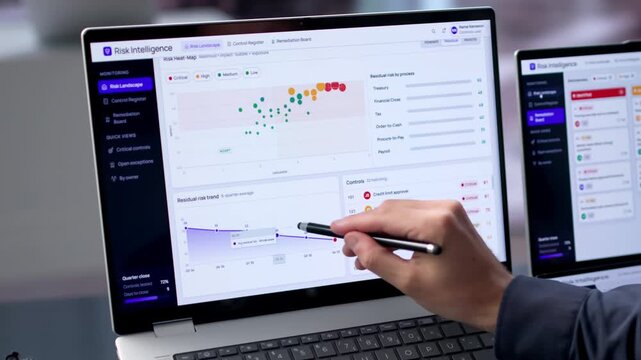Young Male Risk Manager Uses Dual Touchscreen Laptops