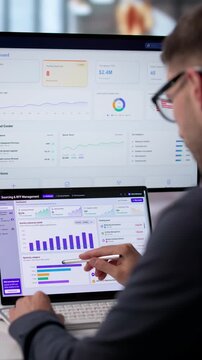 Procurement Manager Analyzes Software On Dual Screen Laptop