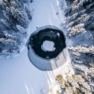 Aerial View of a Modern Igloo Shaped Cabin in a Snowy Forest.