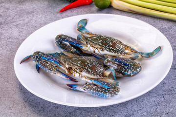 Fresh blue crabs on white plate with chili lime and lemongrass © Andrei Starostin