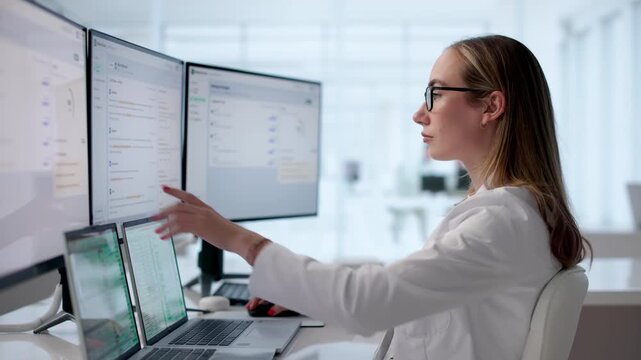Female Medical Scribe Reviews Clinical Notes On Laptop