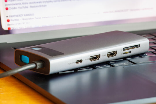 Multiport docking station adapter resting on a computer keyboard for laptops and desktop computers.