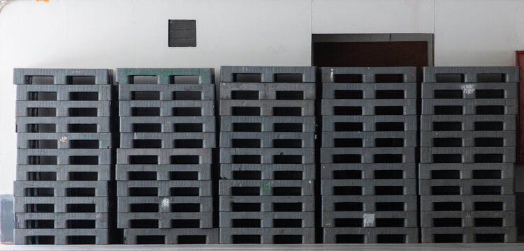 Industrial gray plastic pallets stacked in warehouse