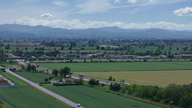 A1 Autostrada del Sole and A21 Autostrada dei Vini meet near Fiorenzuola d'Arda, Piacenza, Emilia-Romagna, Italy, with an Autogrill service area and the Northern Apennines beyond, static.