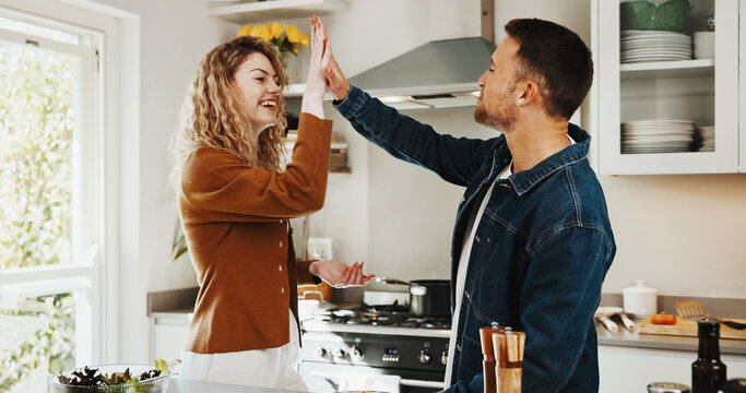 Love, high five and cooking with couple in kitchen for romance, support or connection. Happy, diet win and lunch success with man and woman in home for marriage commitment, celebration and motivation