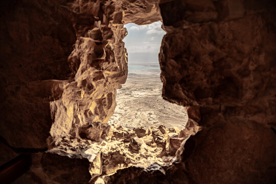 A view  from breach in the wall in the ruins of the Mossad fortress of the adjacent plain and the Dead Sea in southern Israel near Arad