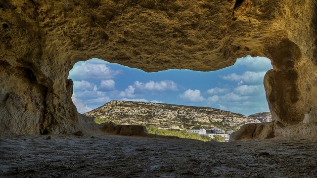 Sky changed, Neolithic caves, former hippie paradise, cave with window view of rocky landscape under blue sky, Matala, south coast, Crete, Greek islands, Greece