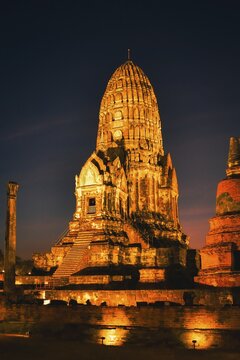 Wat Ratchaburana ancient temple in Ayutthaya, Thailand. Illuminated central prang and ruins under purple twilight blue hour sky. Siam kingdom preserved ancient ruins. Unesco site