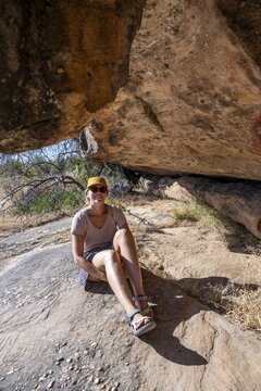 Tourist on a rock with prehistoric animal depictions, ancient rock carving of the San, indigenous people of South Africa, Seville Rock Art Trail, Cedar Mountains, Clanwilliam, Western Cape, Republic of South Africa