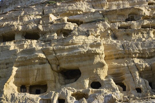 Neolithic caves, former hippie paradise, detail of eroded rock wall with small cave entrances and textures, Matala, south coast, Crete, Greek islands, Greece