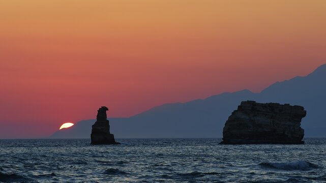 Calming sunset over the sea with a rock and mountains on the horizon, sunset, South of the Amari Basin, Central Crete, Triopetra, rocks in the sea, Crete, Greek Islands, Greece