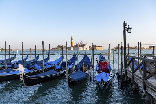 Venetian gondolas, boat launch at St. Mark's Square, San Giorgio Maggiore church in the evening light, Venice, Veneto, Italy