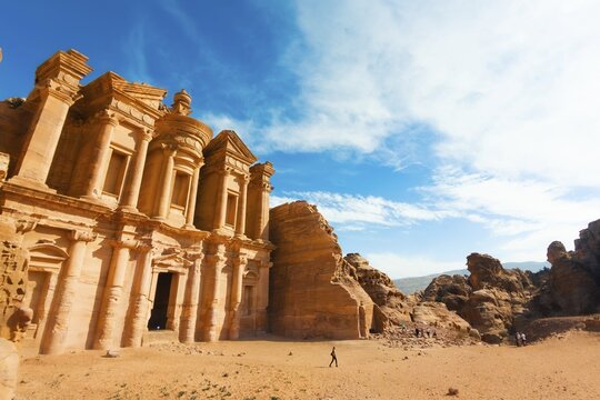 Panorama hilltop Ad Deir Monastery in Petra Jordan. Rock cut Nabataean monument carved sandstone facade UNESCO World Heritage desert landscape in clear sunny autumn day