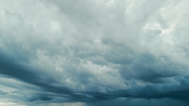 Aerial drone shoot of Dark storm clouds rolling over open green fields before heavy rain. Dramatic shelf cloud formation 