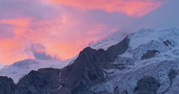 Sunset glow sky over Genie Holy Mountain, Sichuan China, colorful twilight clouds above snow-capped peaks and alpine grassland, western Sichuan plateau landscape