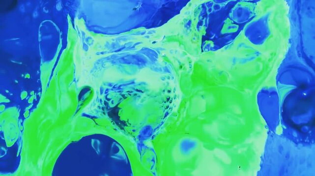 Vibrant green and blue acrylic paint mixing into organic art patterns