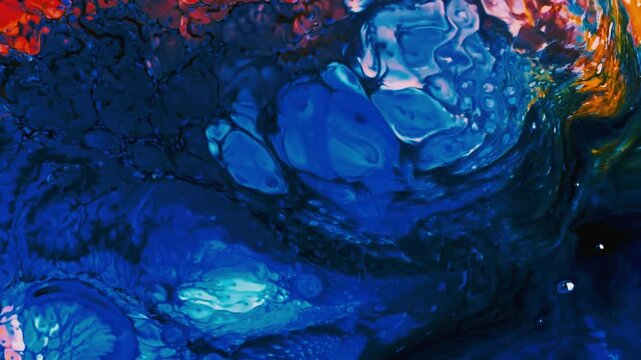 Abstract blue and orange fluid acrylic paint mixing on a flat surface