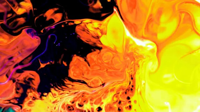 Abstract yellow and orange liquid paint mixing on a dark surface