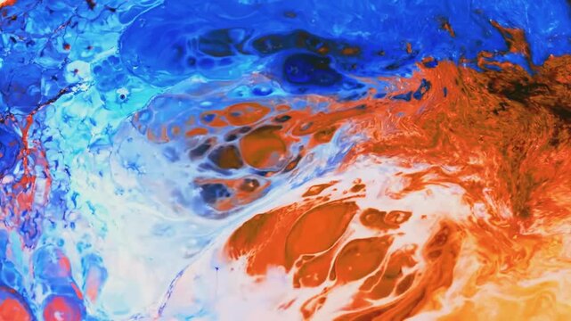 Vibrant blue and orange paint pigments mixing in fluid art patterns
