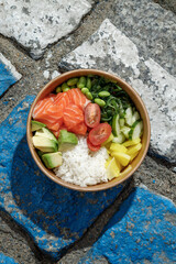 Salmon poke bowl in a delivery box on road markings. Isolated © Cavan