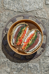 Sushi burger on a metal wire rack. Delivery box. Art photo © Cavan