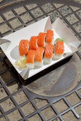 Philadelphia roll with salmon on a metal wire rack. Delivery box © Cavan
