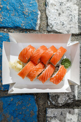 Philadelphia salmon sushi roll on road markings. Delivery box. © Cavan