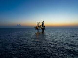 Aerial view of offshore jack up rig and offshore platform during sunset © bomboman