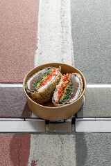 Sushi burger on road markings. Delivery box. Art photo. © Cavan
