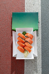 Philadelphia salmon sushi roll on road markings. Delivery box. © Cavan