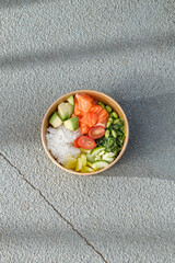 Salmon poke bowl in a delivery box on road markings. Isolated © Cavan