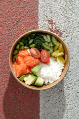 Salmon poke bowl in a delivery box on road markings. Isolated © Cavan