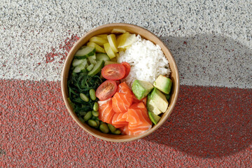Salmon poke bowl in a delivery box on road markings. Isolated © Cavan