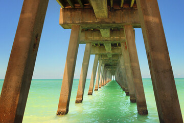 Obraz premium View from under a long concrete pier into the ocean