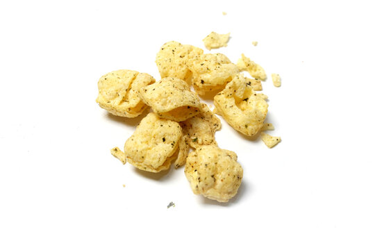 pile of crispy seasoned puff chips scattered on an isolated white background.