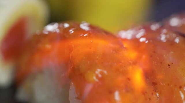 Extreme close up of seared salmon sushi roll with glaze